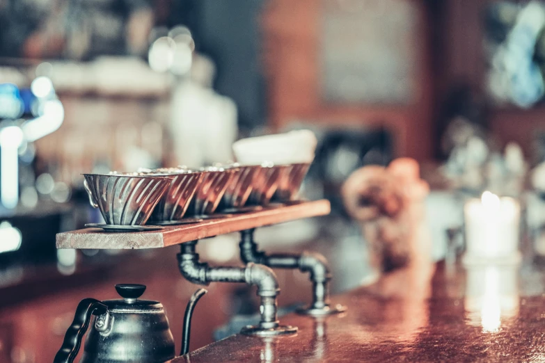 a wooden table topped with lots of metal cups