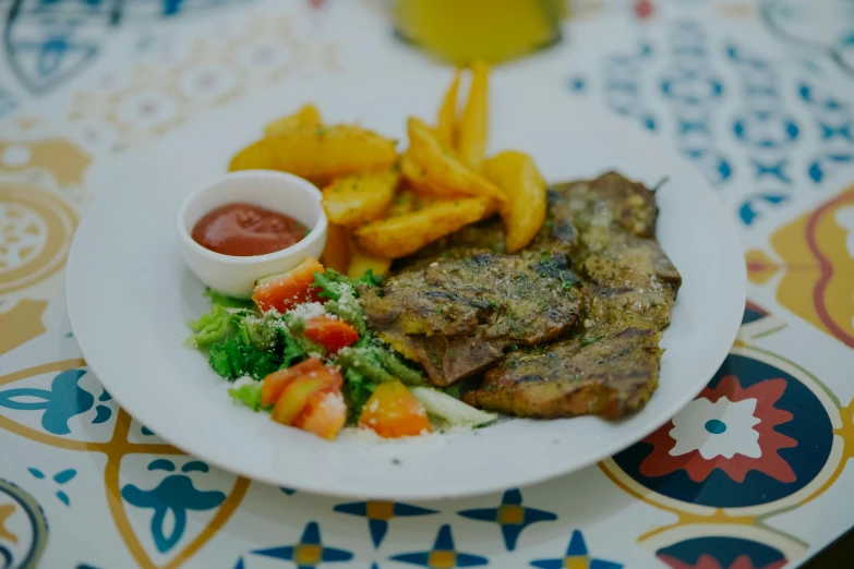 meat and french fries are on a plate with a side of ketchup