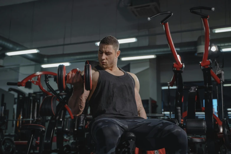 a man in a gym holding a barbell and looking to his left