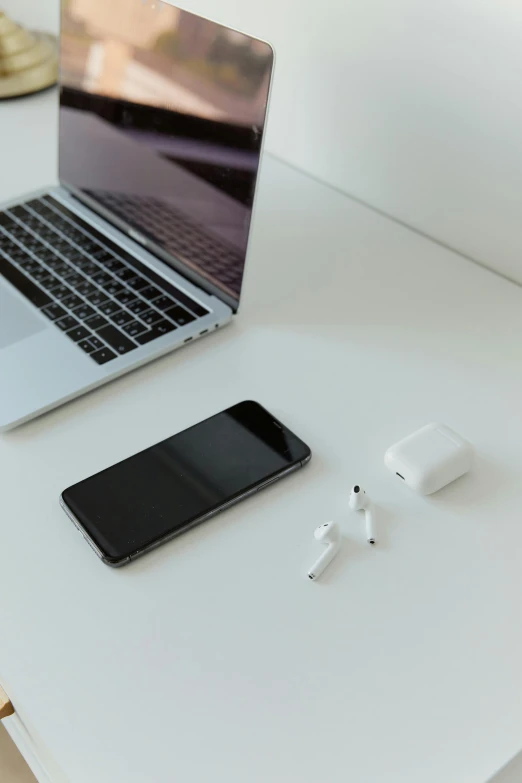 a laptop and ear buds sitting on a desk