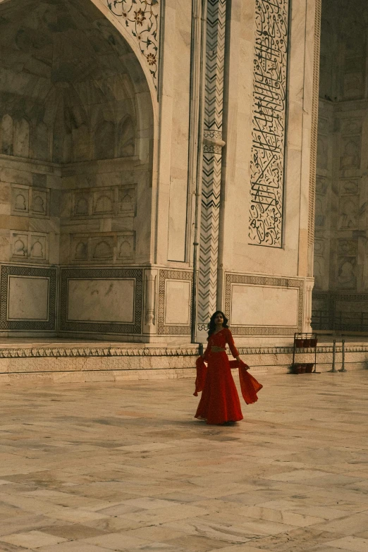 a girl in red standing outside of the white building