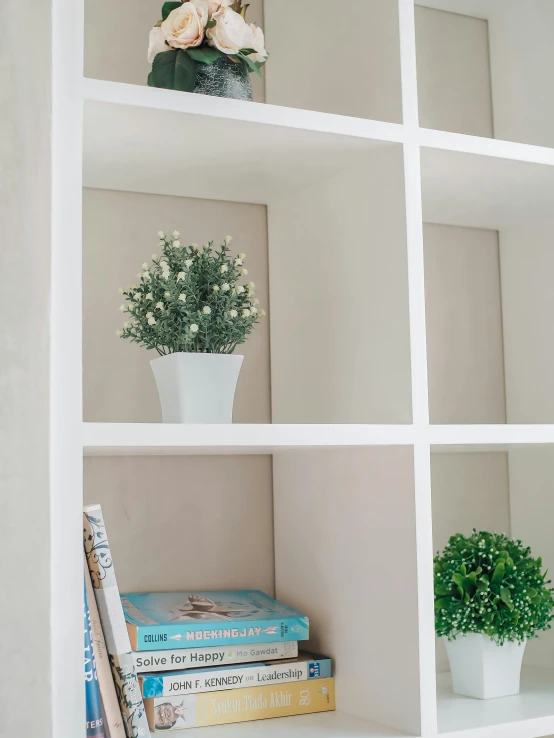 four white book shelves with flowers on them