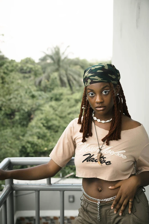 a woman with dreadlocks stands with her hands on her hips