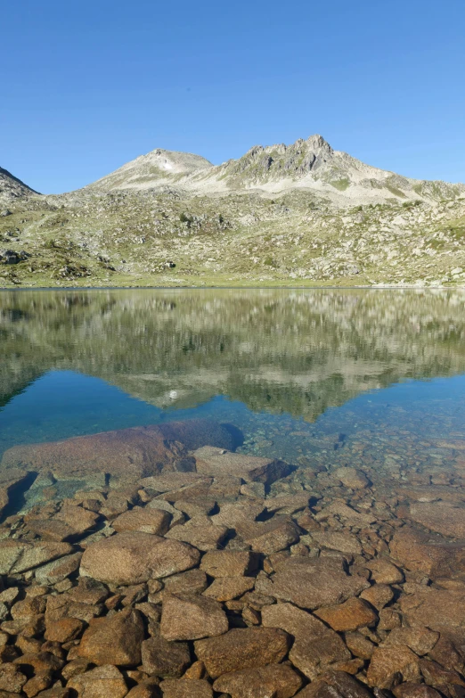 a calm mountain lake surrounded by rocky landscape