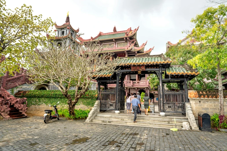 a group of men walk near a pavilion in an asian town