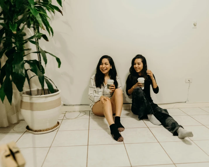 two women in black and white are sitting on the floor