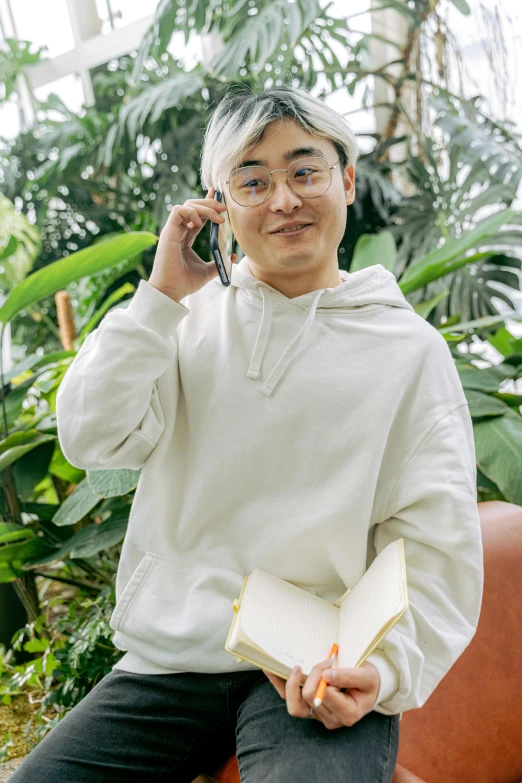 a man talking on a cellphone next to plants