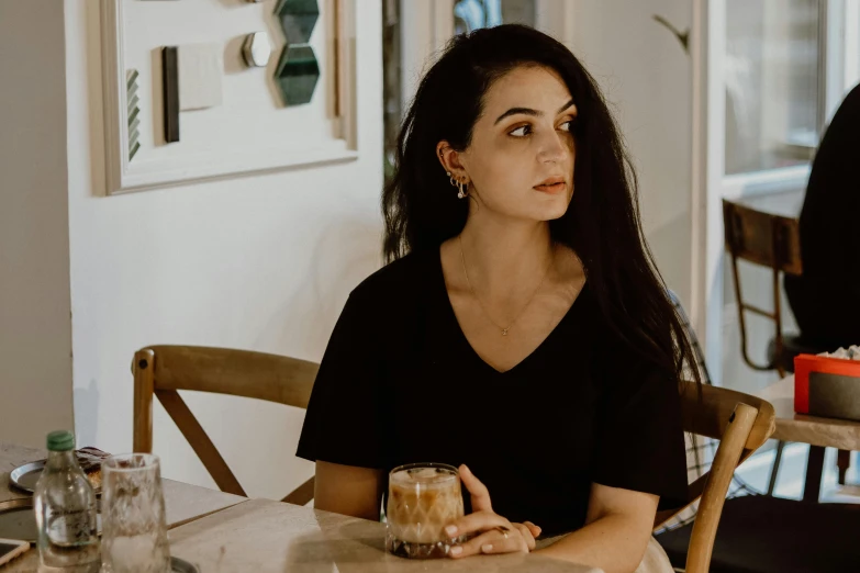 woman holding glass sitting at table with milk and peanut er