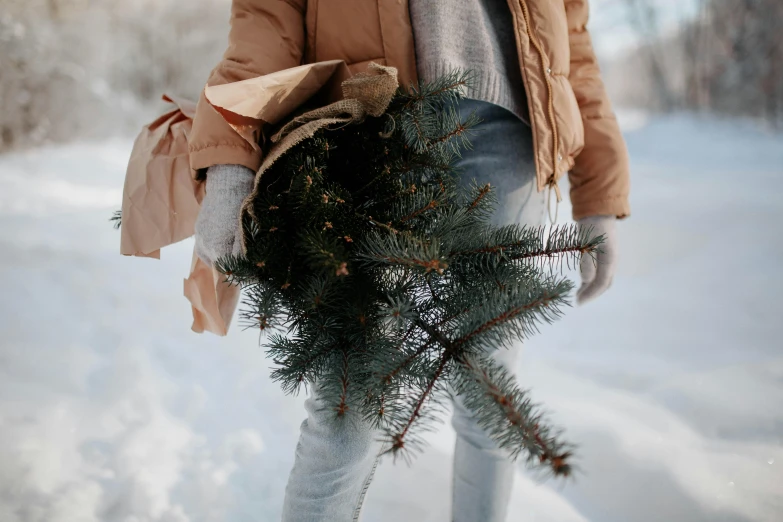 a woman is walking in the snow carrying a bunch of nches