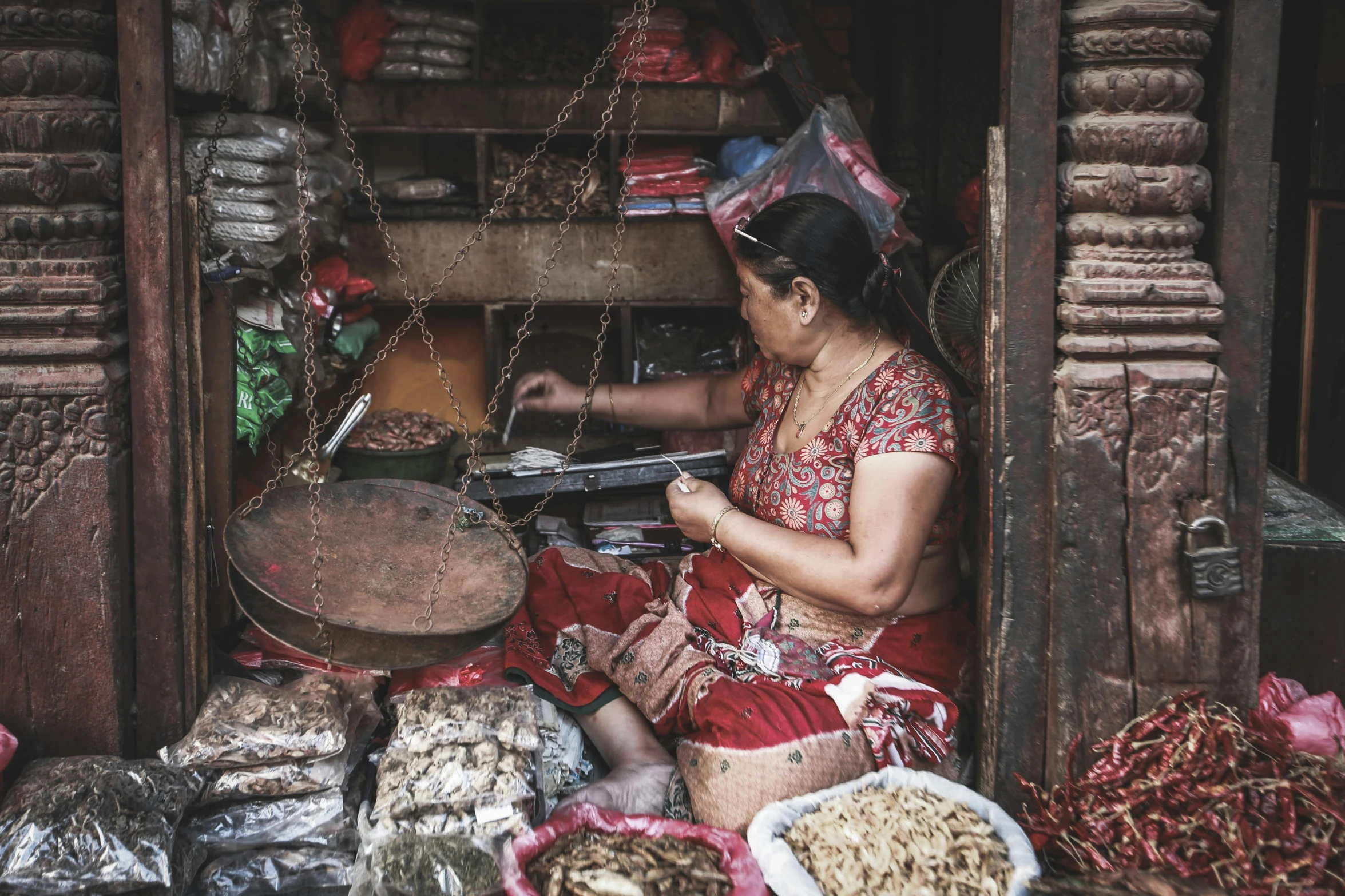 a woman is sitting on the floor in her hut while cooking