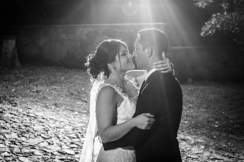 a bride and groom standing under a light at their wedding