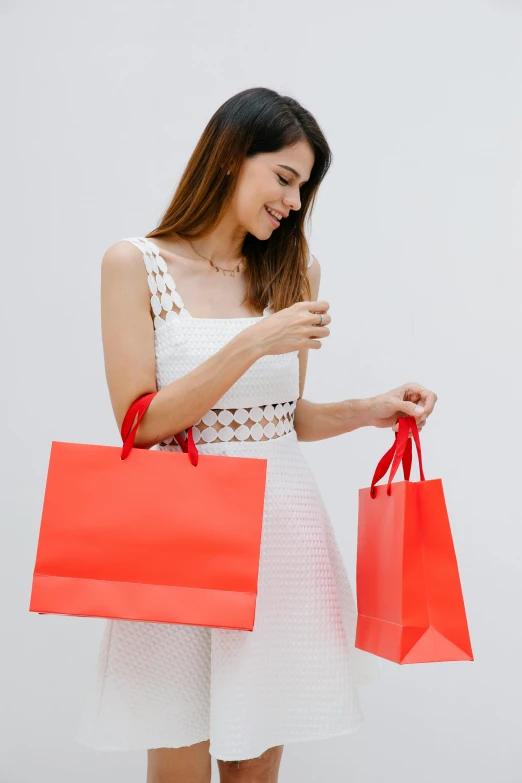 a woman holding two red shopping bags