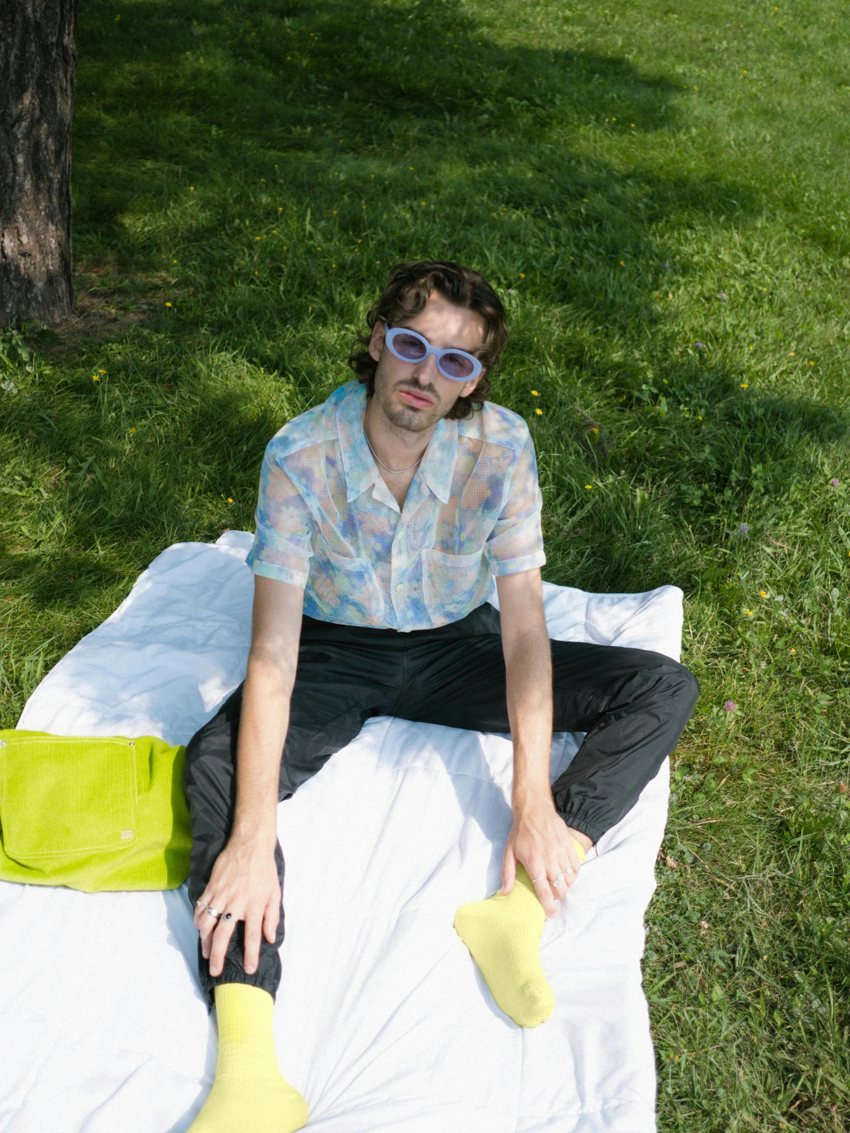 the man is wearing sunglasses and a shirt with different items on it