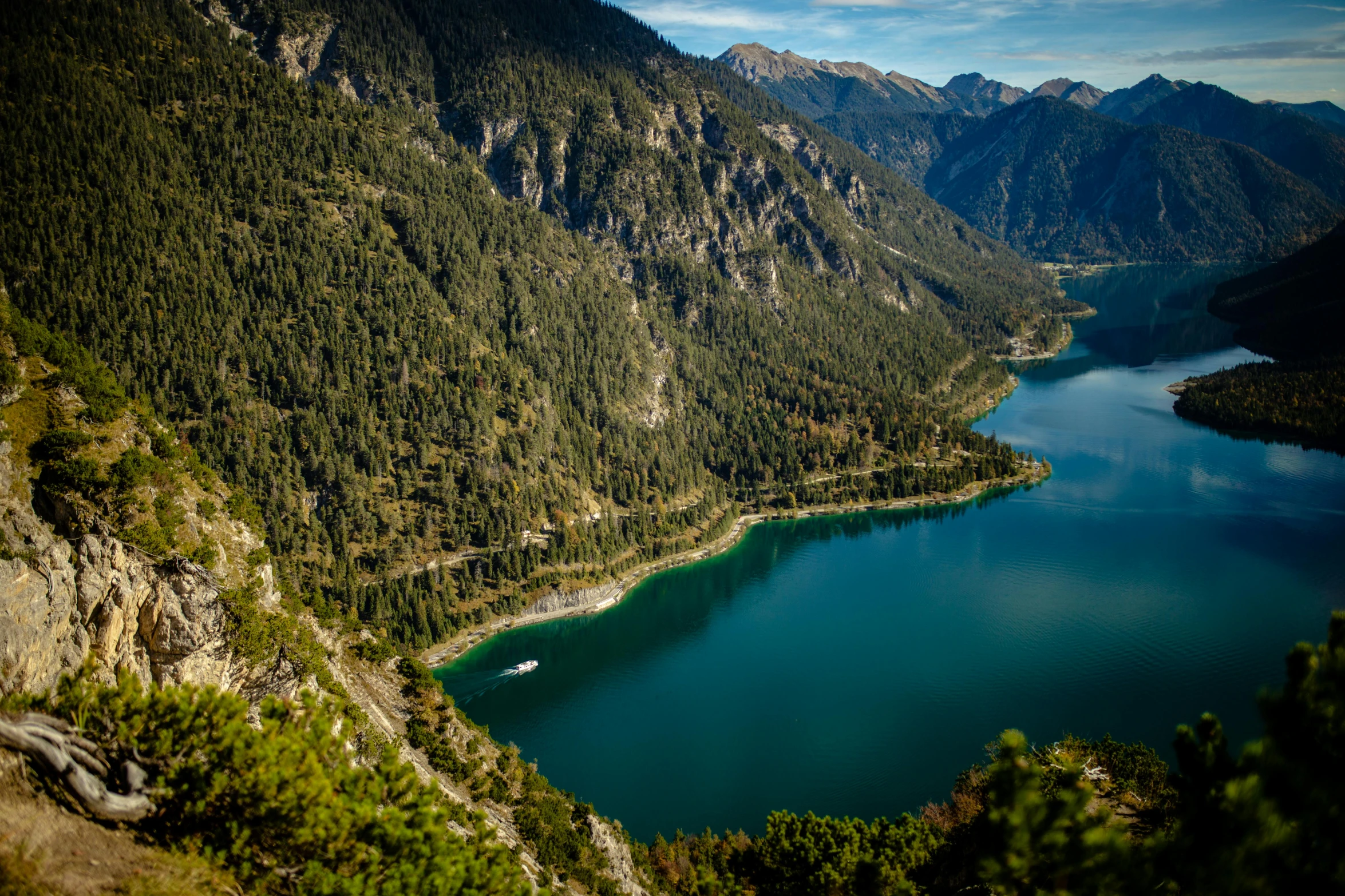 a boat travels down the water near the mountains