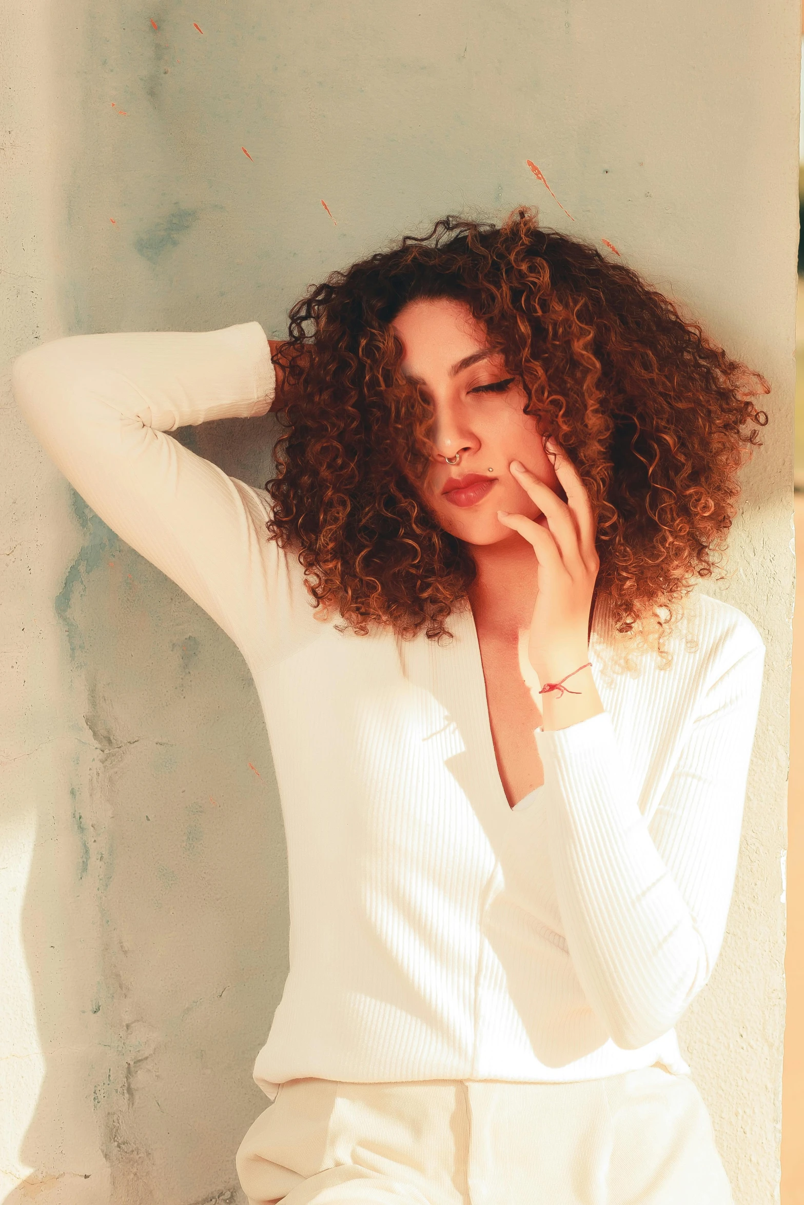 a woman poses with her hands on her head