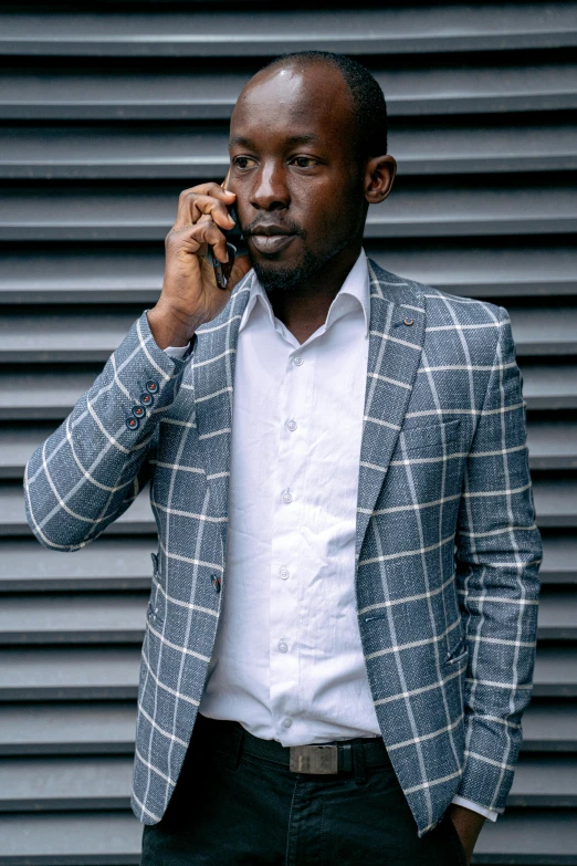 a man in a blue jacket talking on the cellphone