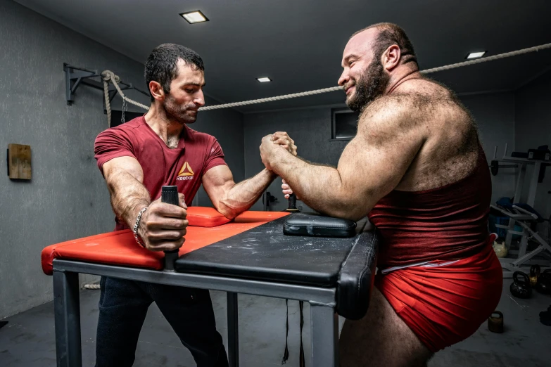 two men engaged in fighting in a gym