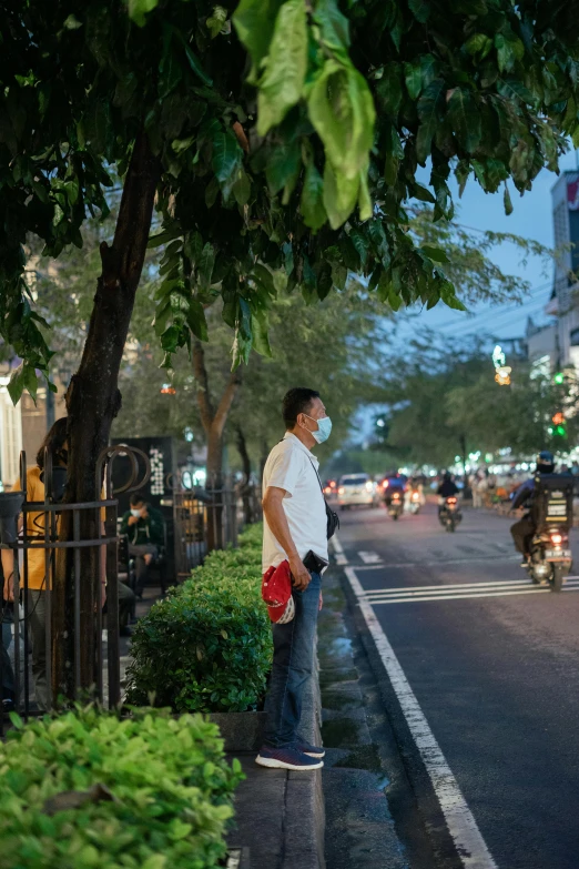 a man standing on a curb with his mask on