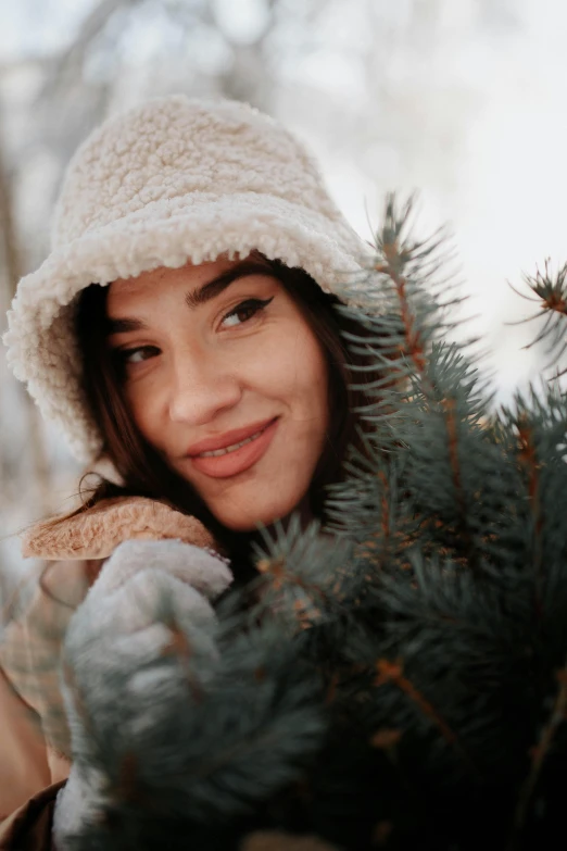 a young lady is holding onto a fir tree