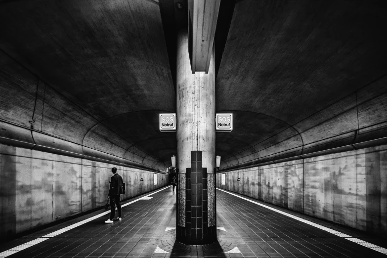 man standing at the end of a tunnel in an abandoned building