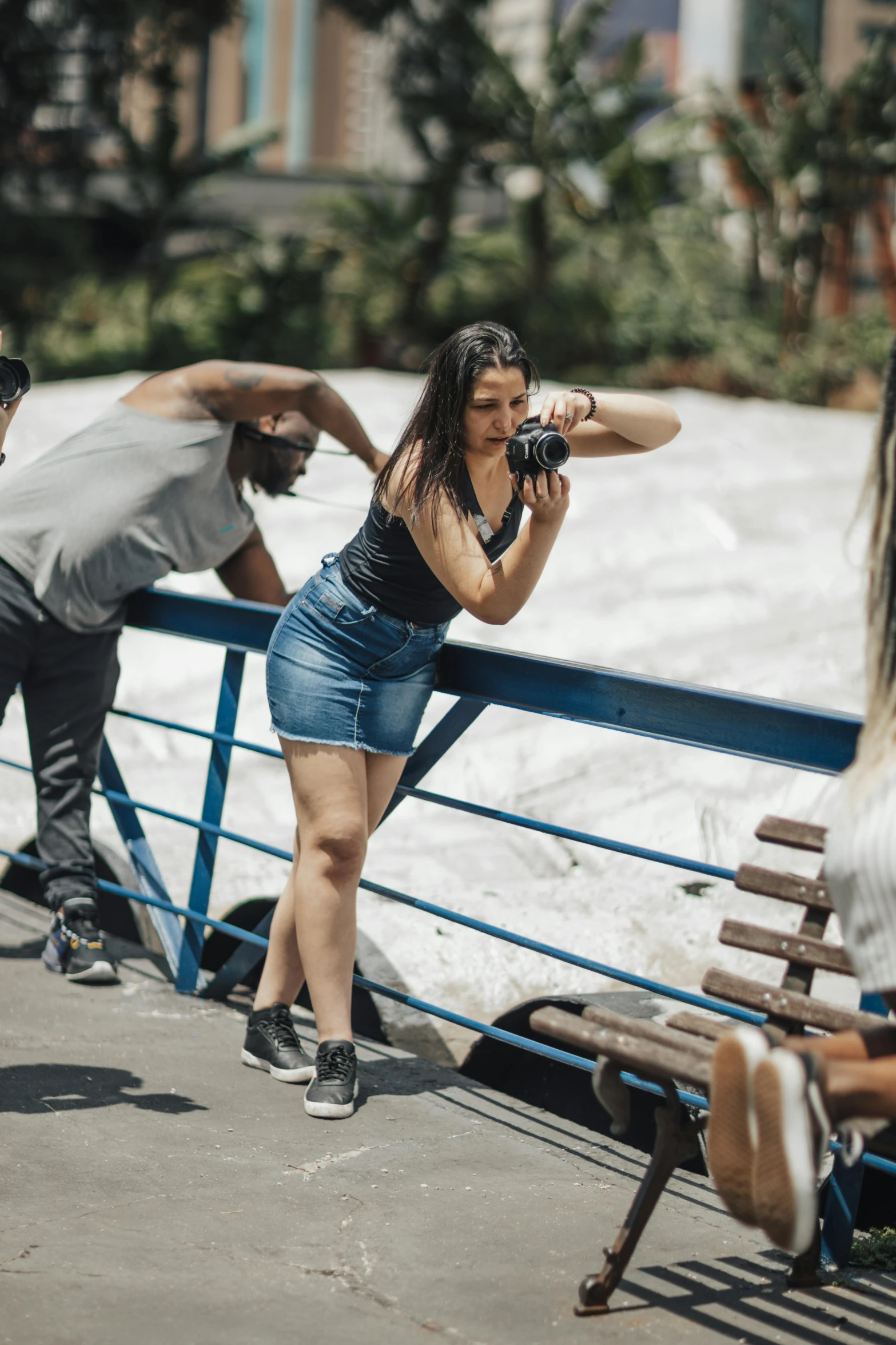 woman is leaning against the side of a rail taking a po