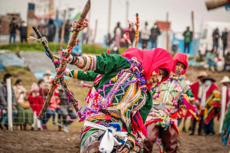 a man riding on the back of a horse wearing an outfit and holding poles