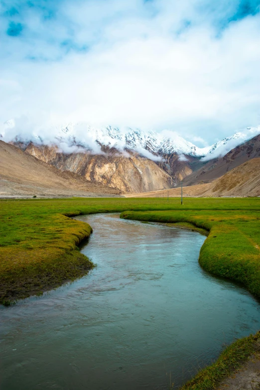 water running through the field next to mountains