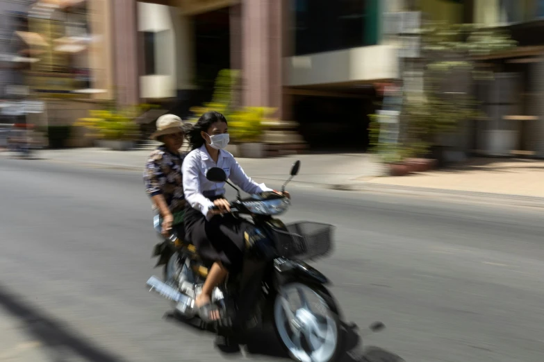 two people riding on a motorcycle in the city