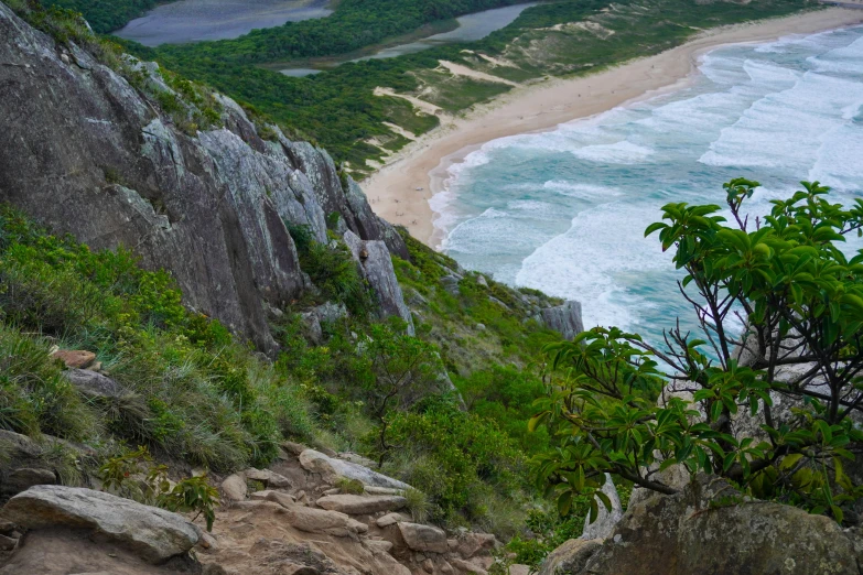 the view of a beach from a cliff above the ocean