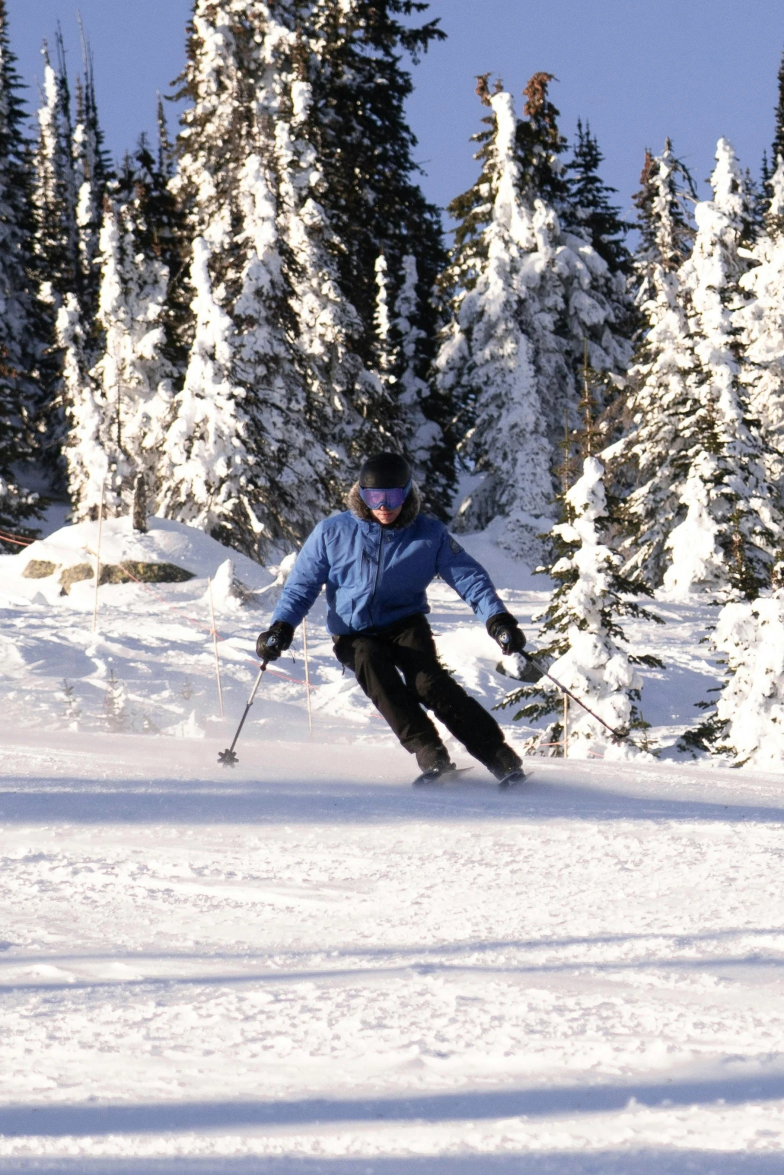 there is a person skiing down the snow covered slopes