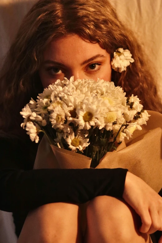 a woman is holding a bunch of flowers