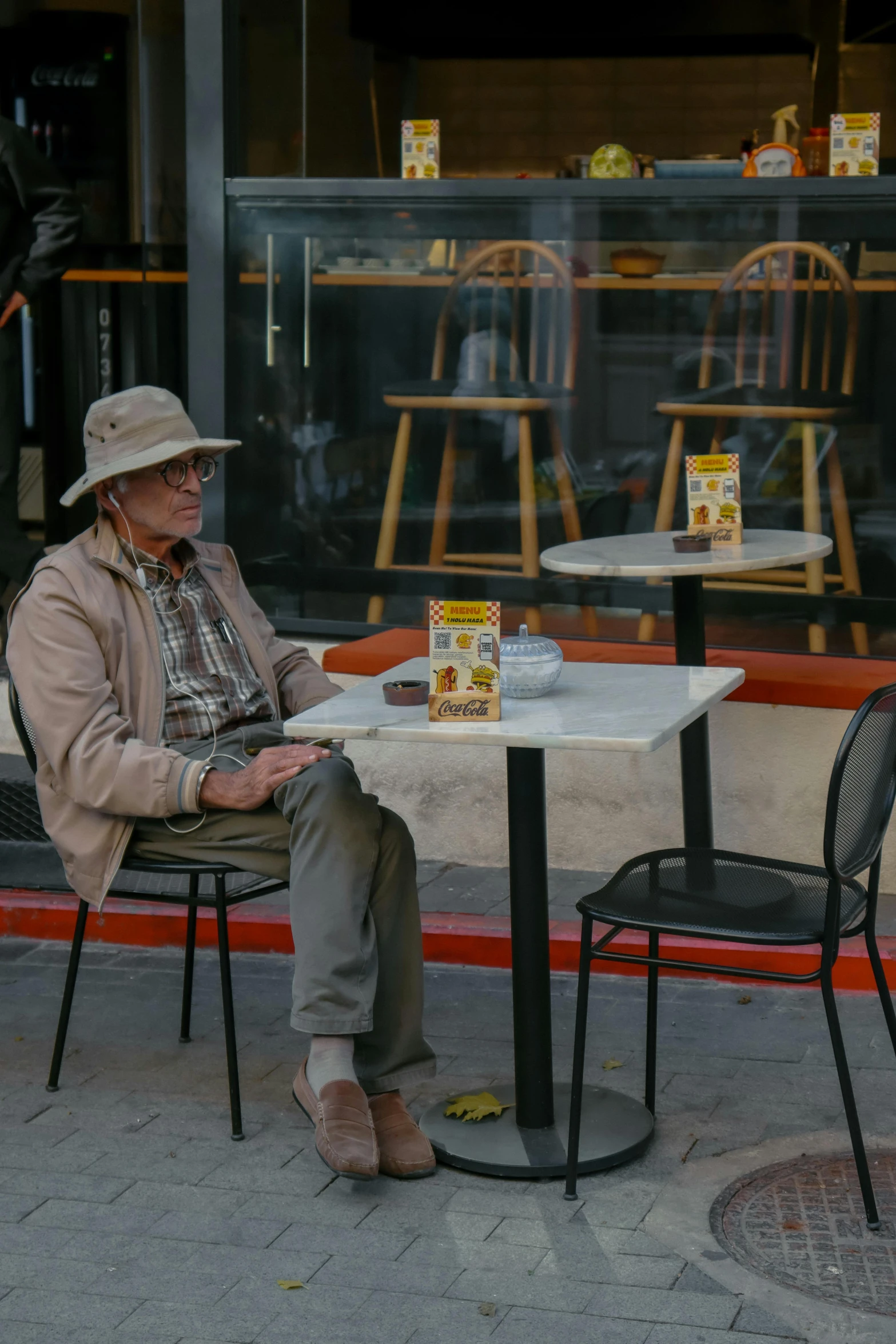 the man is sitting at the table outside reading the book