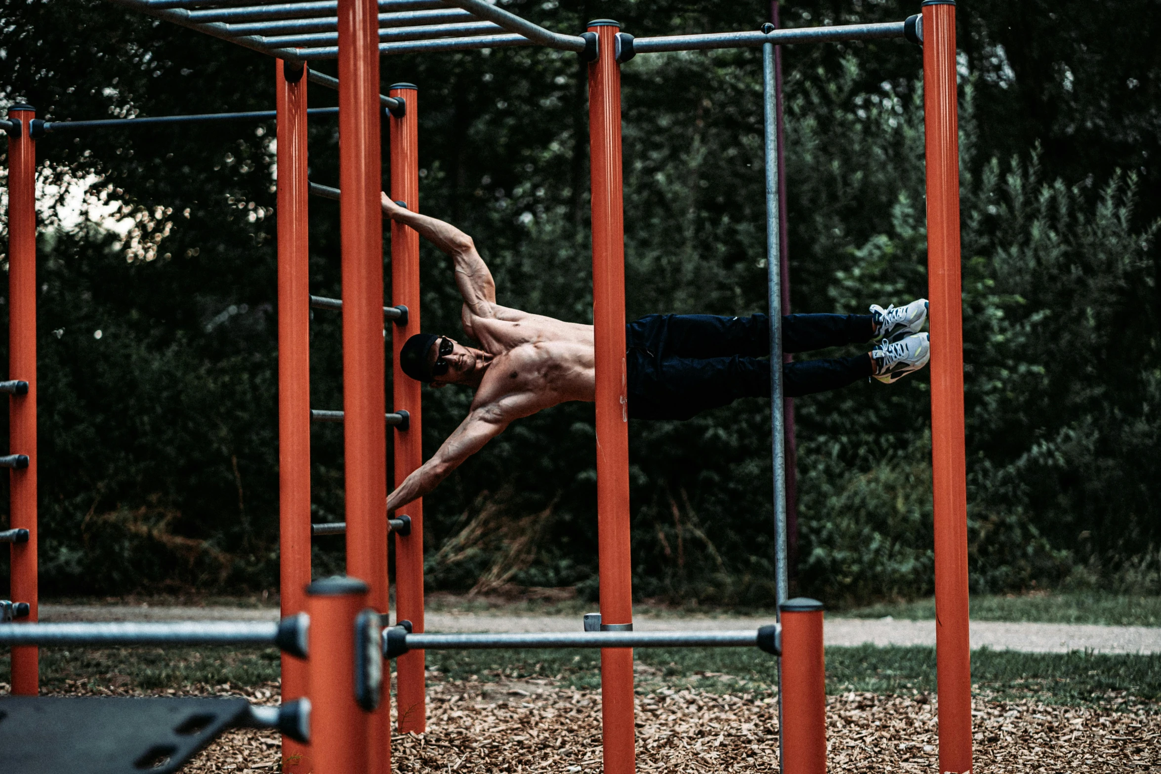 the man is doing a hup on the rings in the gym