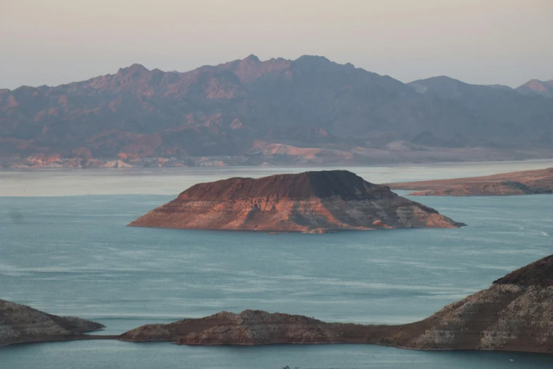 mountains are seen in the distance along the water