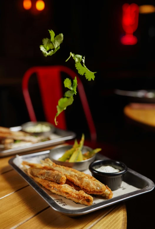 a tray topped with food next to another tray filled with salad