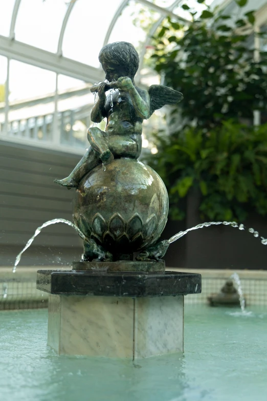 a statue of a child sitting on a water spout