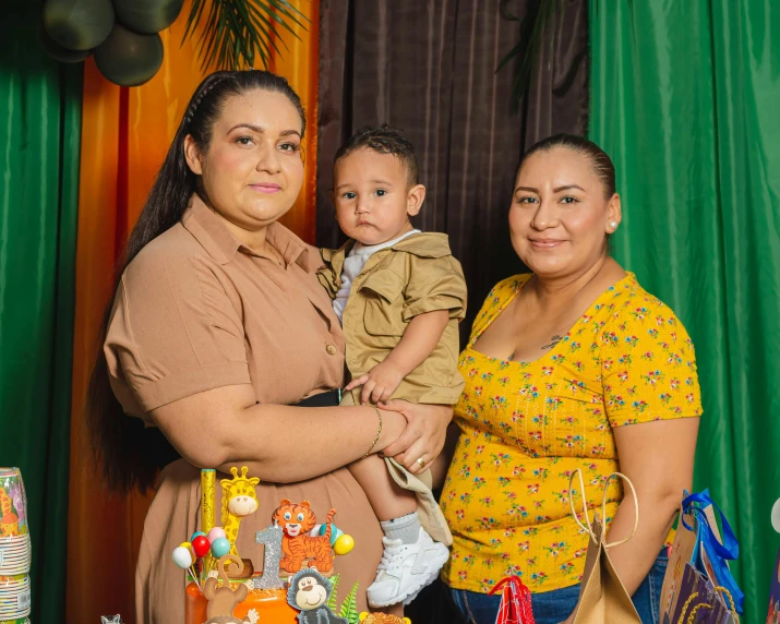 a man and a woman holding a baby near many decorations