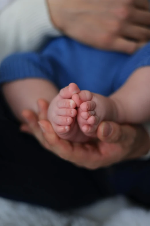 a man is holding a tiny baby in their hands