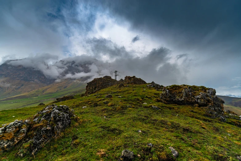 rocks and grass on a grassy hill on a cloudy day