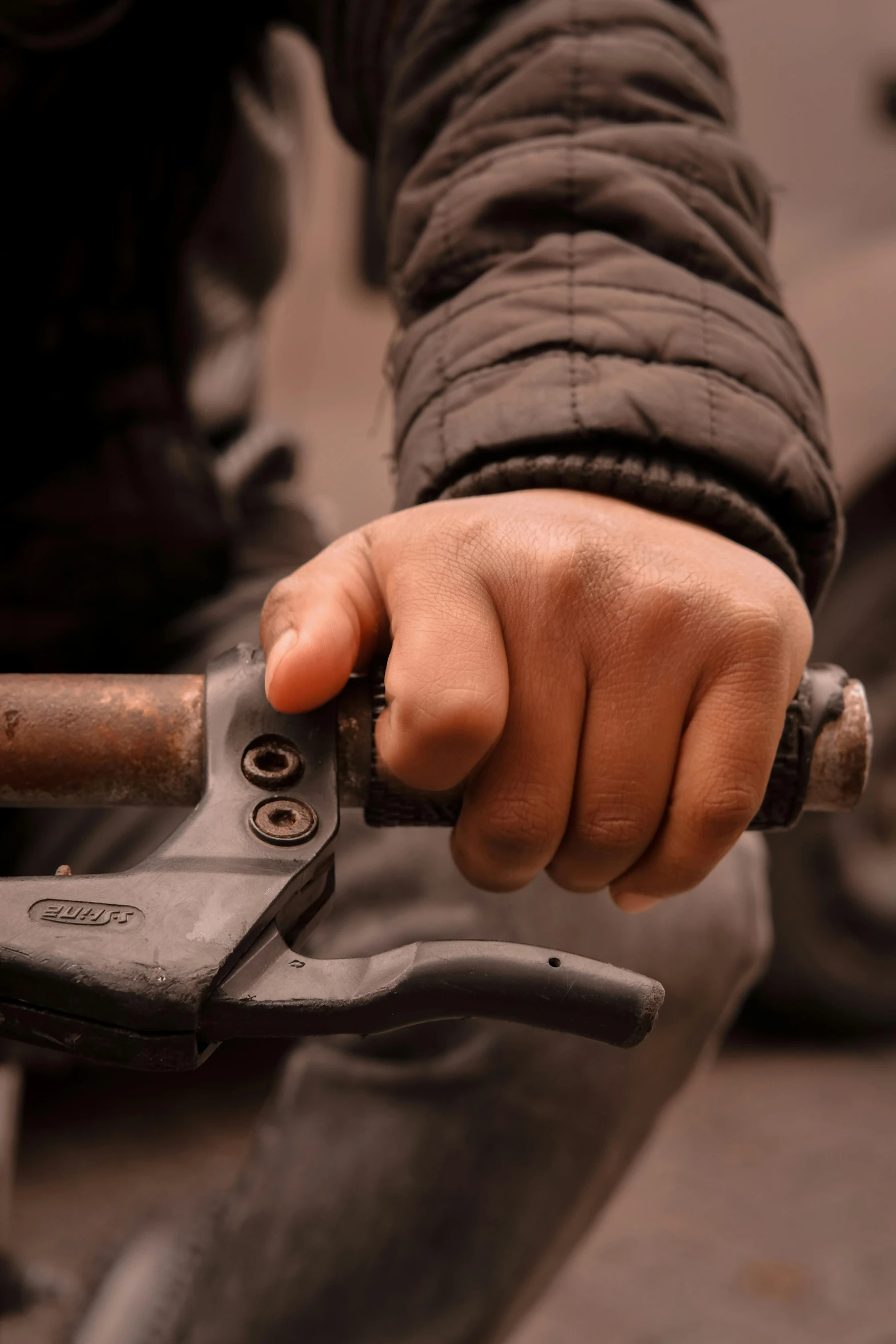 person's hand holding a hammer and a wrench