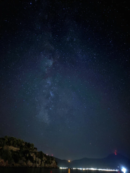 a boat on the water at night with the sky in the background