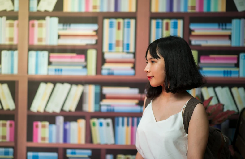 a woman standing in front of shelves with books