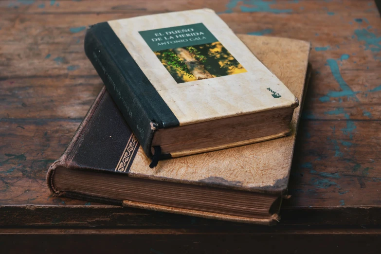 a brown book sitting on top of two other books