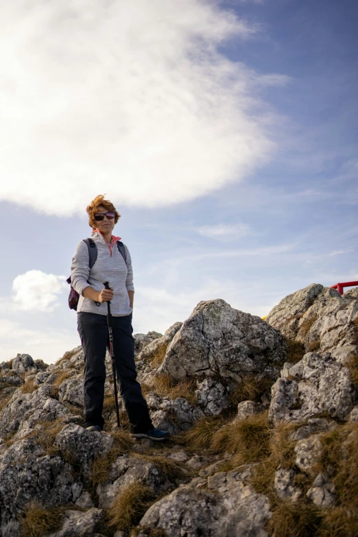 a woman standing on the edge of a rocky area