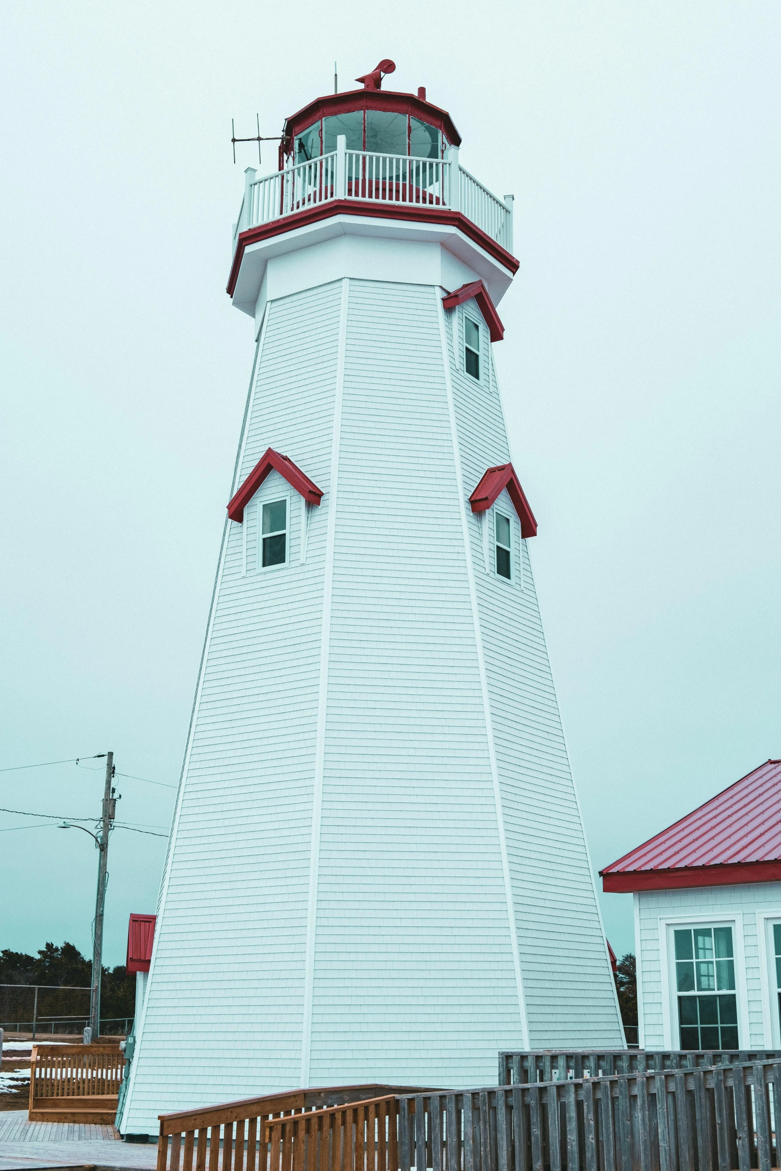 a large white and red lighthouse sitting on top of a beach