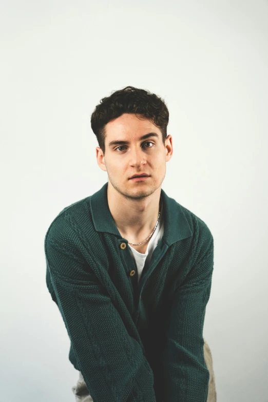 young man posing for a pograph while holding his arm on his chest