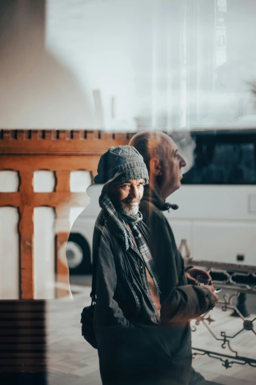 a man with a hat is standing by a bench