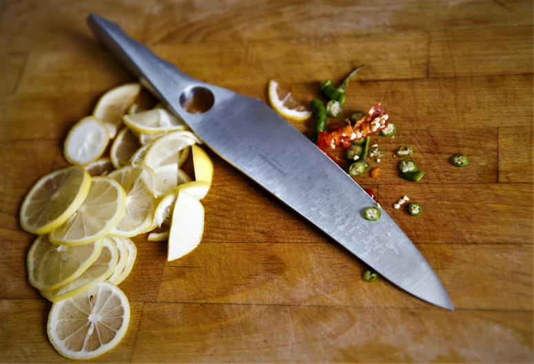 there is a large knife  up food on a wooden  board