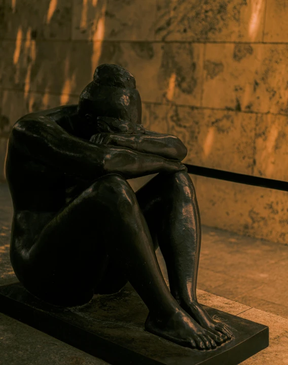 a bronze statue sits on a cement block