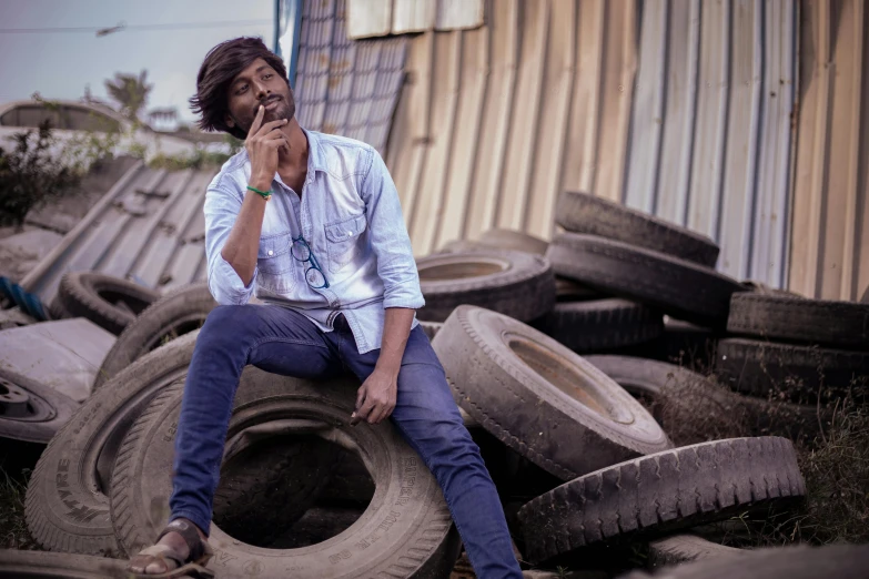 a man sitting on a pile of old tires